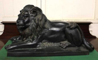 A cast bronze model of a recumbent lion 53cm