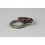 A 9ct gold amethyst and colourless gemset ring mounted with three circular cut amethysts,