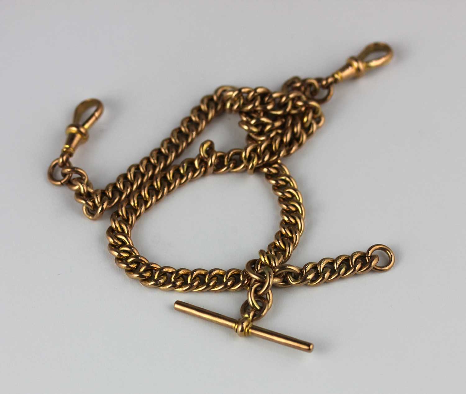 A gold hollow curb link gentleman's watch Albert chain fitted with a gold T bar and two gold swivels