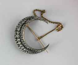 A late Victorian gold backed and silver set diamond crescent brooch in a three row design mounted