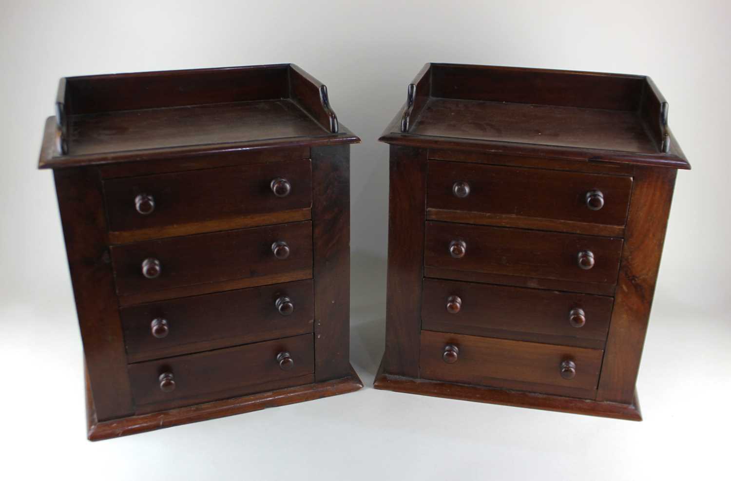 A pair of Victorian mahogany apprentice chests, each having a three-quarter gallery top above 4