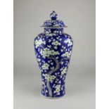 A Chinese porcelain vase and cover decorated with prunus blossom on blue ground, character marks