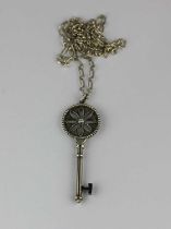 A Tiffany & Co silver and diamond pendant designed as a key with a Tiffany & Co silver bar and