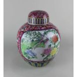 A Chinese ceramic pink ground ginger jar and cover decorated with panels of birds and flowers 29cm