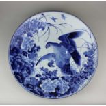 A Japanese blue and white porcelain charger decorated with a bird of prey amongst flowers and