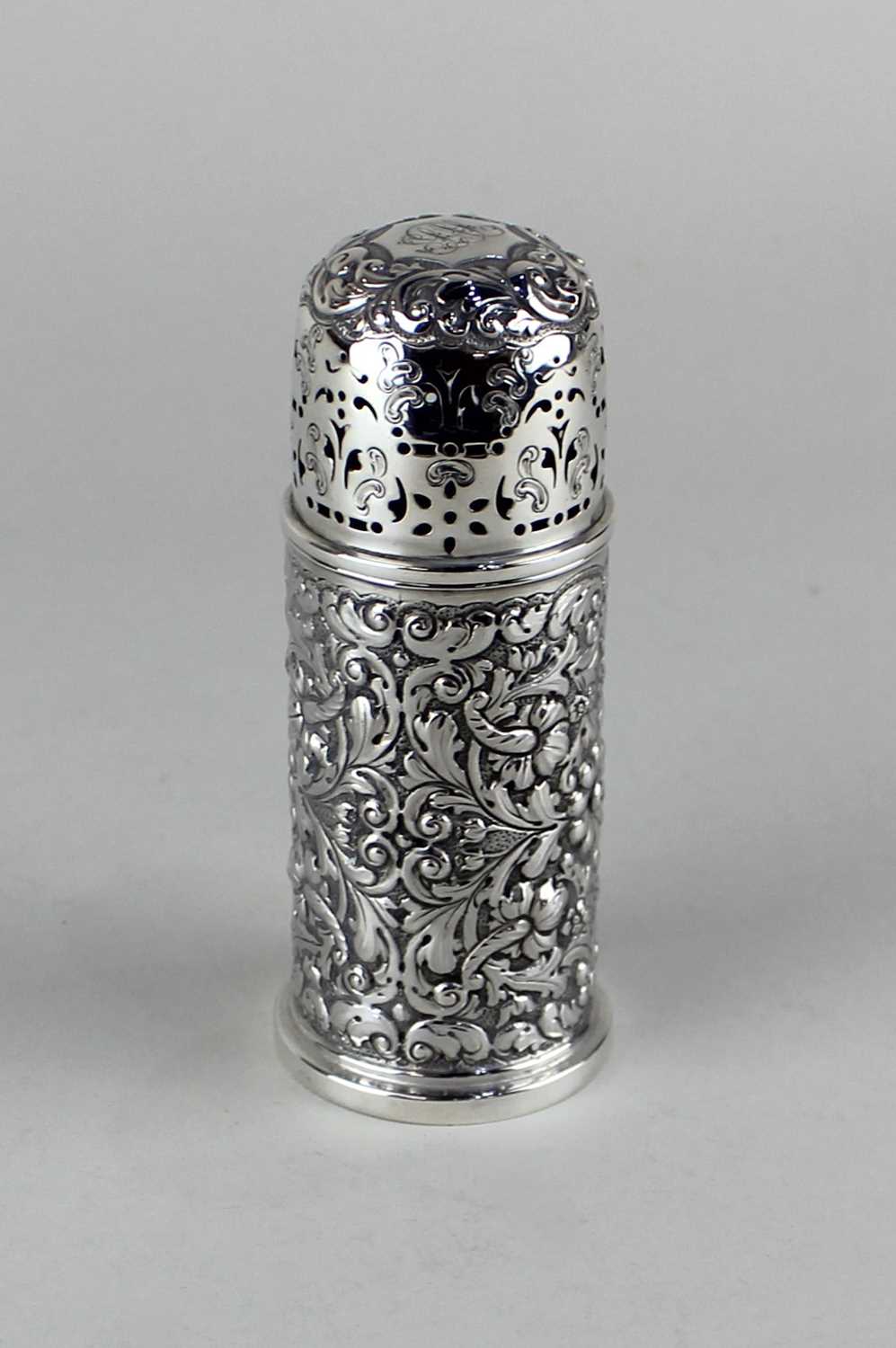 An Edward VII silver sugar caster with embossed floral decoration, engraved monogram to lid, maker
