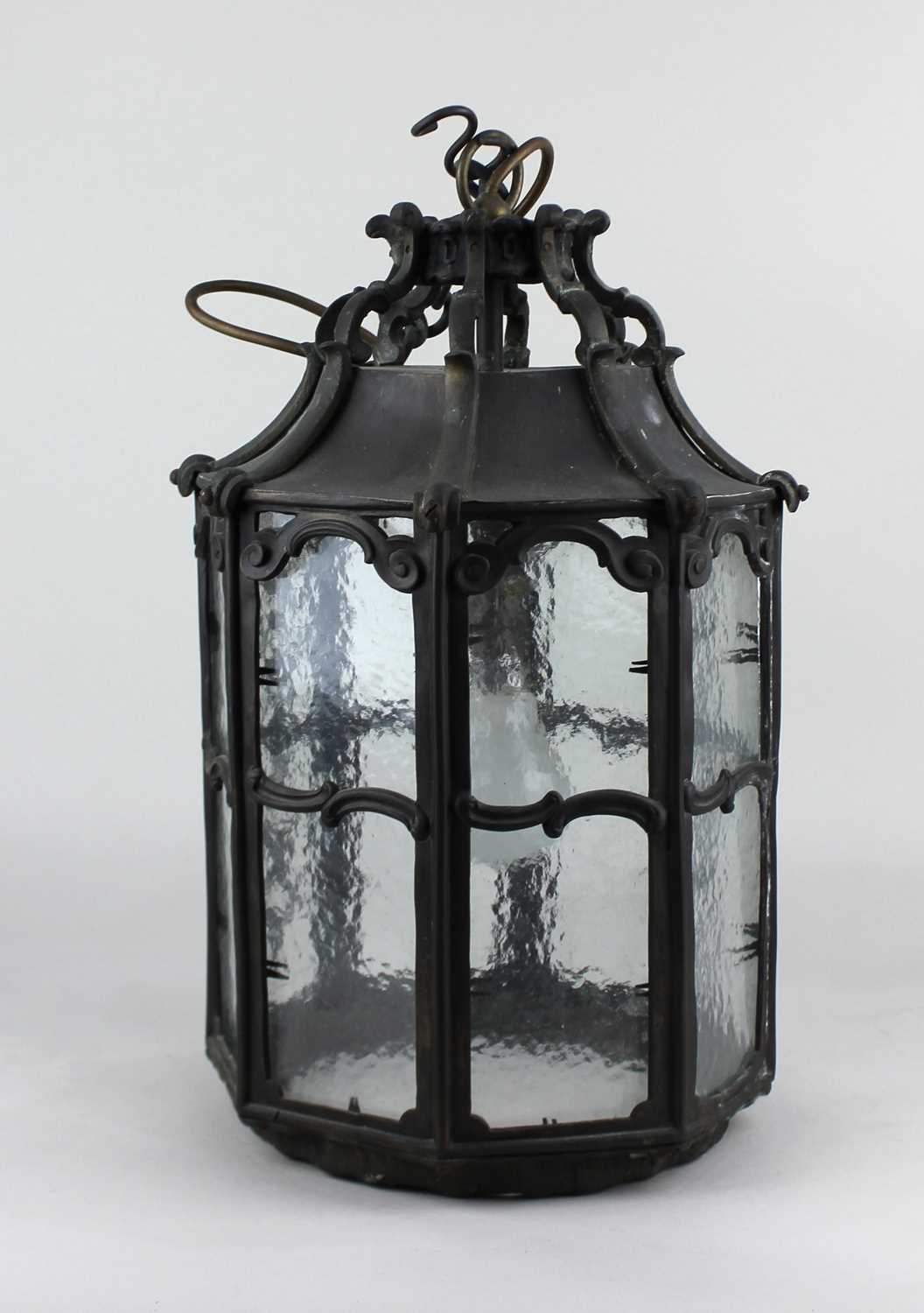 A bronzed hanging lantern in the Arts & Crafts style the octagonal form having ogee supports and