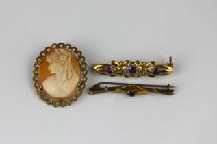 A 9ct gold and amethyst three stone bar brooch, a 9ct gold mounted oval shell cameo brooch,