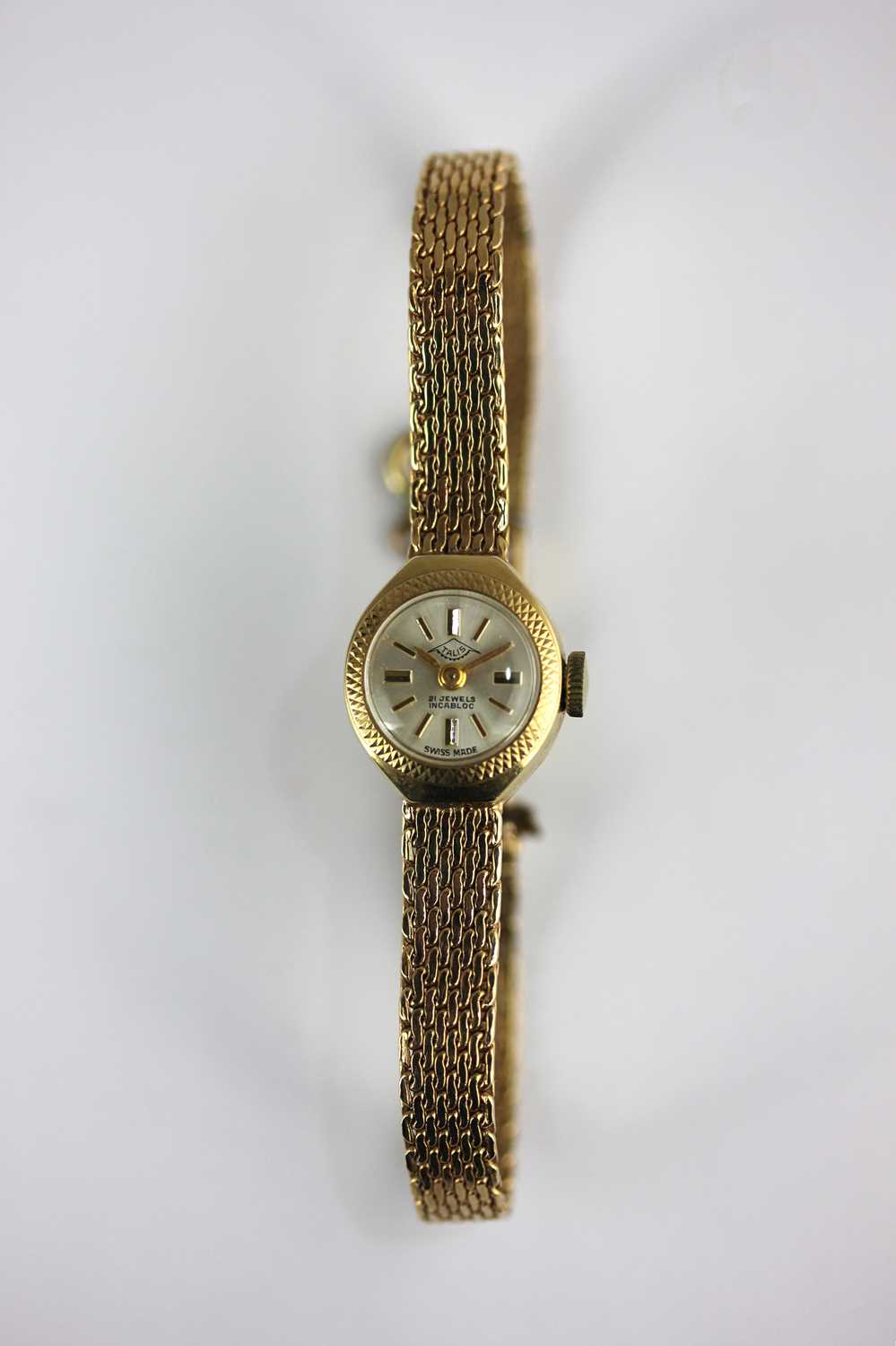 A Talis 9ct gold lady's bracelet wristwatch the signed circular silvered dial with gilt baton