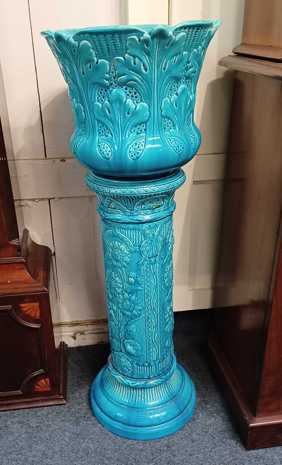 A Burmantofts Faience turquoise glazed jardiniere and stand, the jardiniere cast in low relief