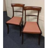 A pair of Regency mahogany dining chairs with rope twist centre rails, red upholstered drop in