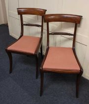 A pair of Regency mahogany dining chairs with rope twist centre rails, red upholstered drop in