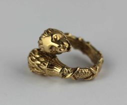 An unmarked yellow metal ring designed as two lion's heads in a crossover design, ring size O, 16.