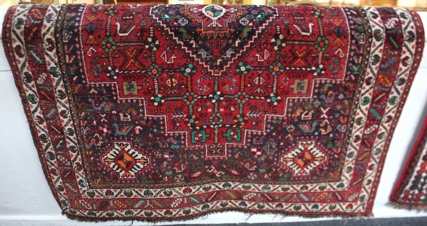 A Persian rug, red ground with central diamond-shaped medallion within a field of stylised