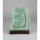 A Chinese jade plaque decorated with birds and fish 20.5cm high, on wooden stand