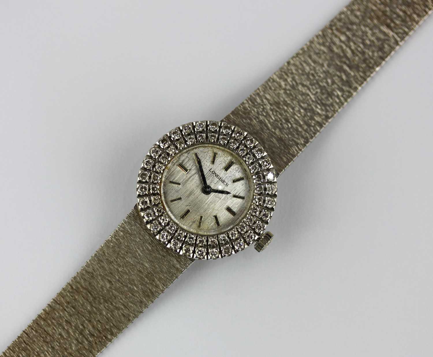 A Longines 18ct white gold and diamond lady's dress bracelet watch, the signed textured silvered