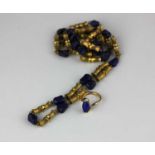 A gold and lapis lazuli necklace formed as bamboo design links alternating with lapis lazuli beads