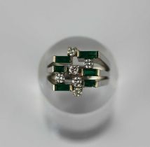 A white gold emerald and diamond ring mounted with six rectangular cut emeralds and with six