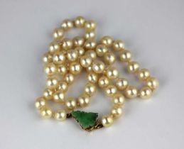 A single row necklace of cultured pearls on a gold and jade clasp detailed '18k'