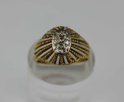 A two colour gold and diamond oval cluster ring in an alternating bar and twist wirework design,
