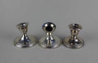 A pair of sterling silver dwarf candlesticks with circular loaded bases, stamped sterling, 7.5cm (