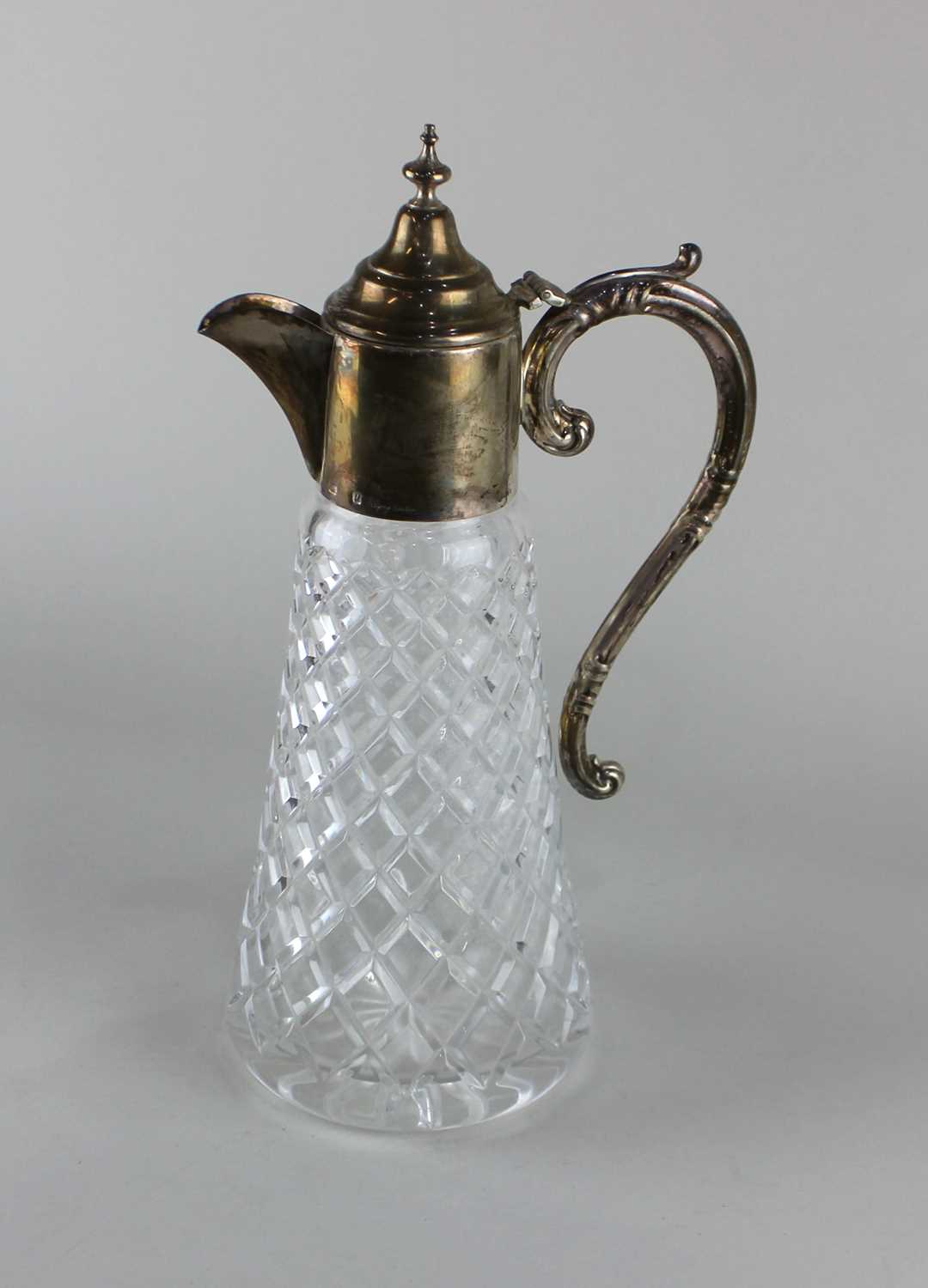 A modern silver mounted glass claret jug marked Asprey, London, with domed lid and scroll handle, on