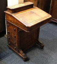 A Victorian walnut Davenport desk with stationary box above a leather inset writing flap enclosing