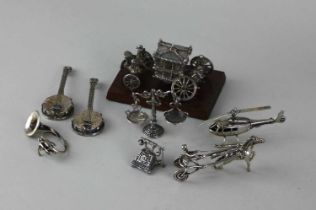 A collection of miniature silver models comprising an Elizabeth II silver cast commemorative