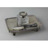 An Edward VII silver desk stand rectangular shape with gadrooned border, glass silver topped inkwell