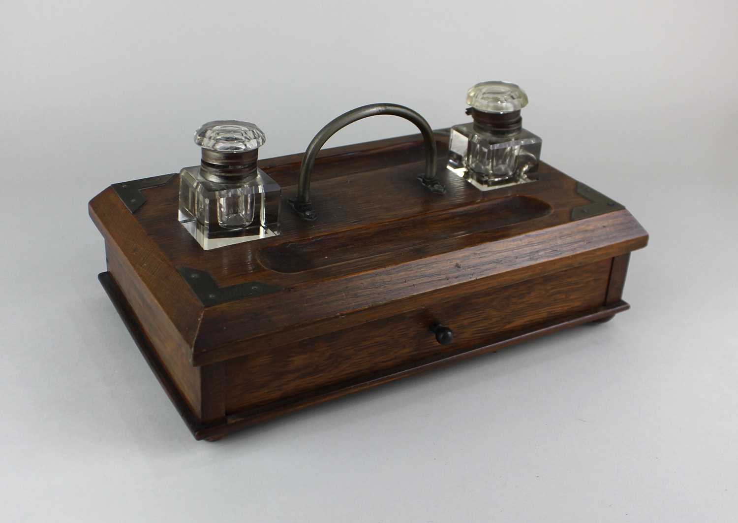 An oak and brass mounted desk tidy with two glass inkwells 28cm