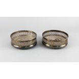 A pair of modern silver bottle coasters with pierced sides, turned wooden bases, maker C J Vander,