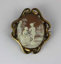 A Victorian gilt metal mounted oval shell cameo brooch carved as a courting couple feeding a goose