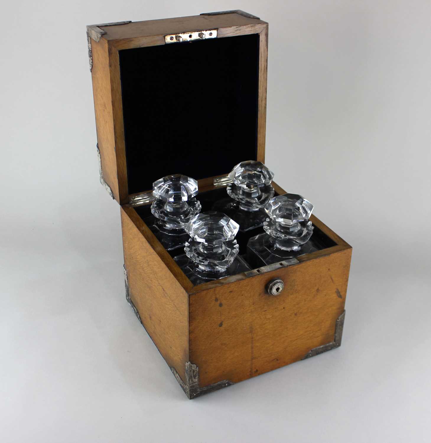 A good quality Victorian light oak decanter box applied with silver plated corner mounts, the hinged