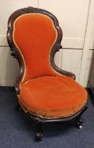 A Victorian carved walnut show-wood lady's chair, upholstered back and seat, raised on ceramic