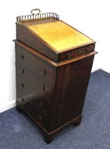 A small Victorian oak Davenport, with pierced gilt metal three quarter gallery above a leather inset