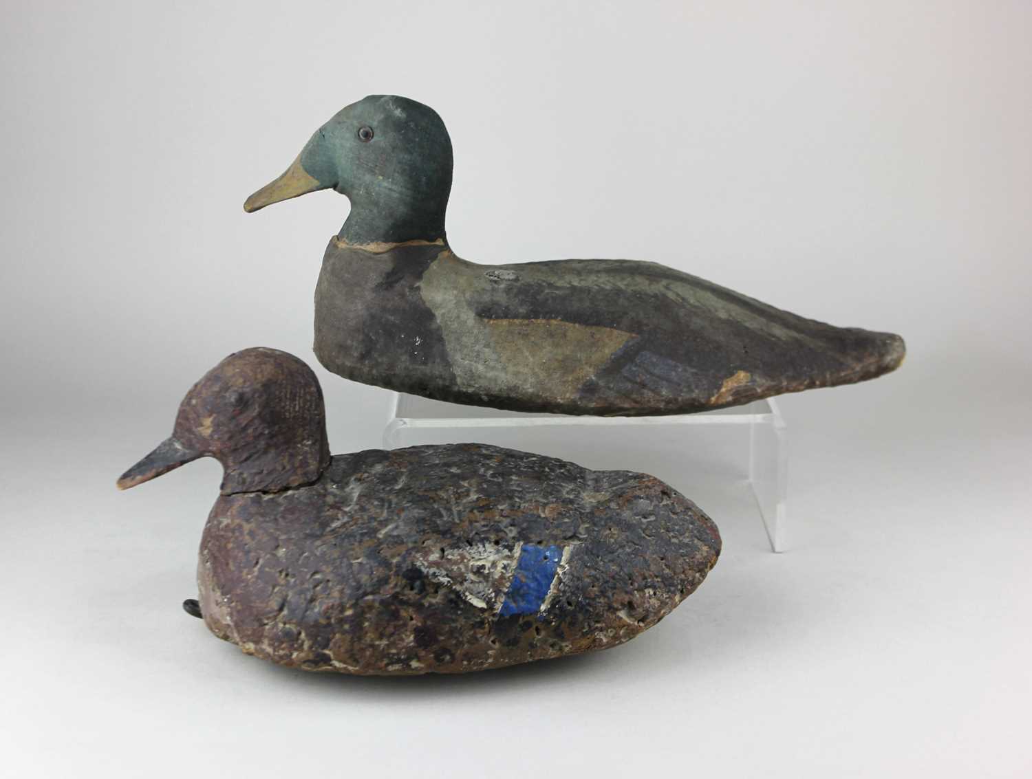 An early carved wooden decoy duck, with traces of original paintwork, underside with old metal