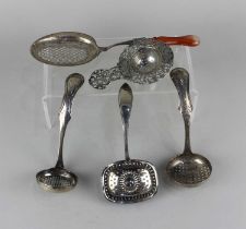 A collection of five Dutch silver tea strainer spoons of various styles, 5oz