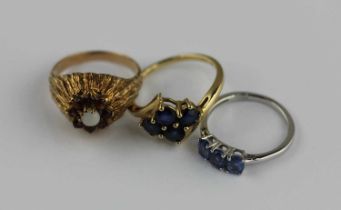 A 9ct gold and sapphire four stone ring in a twist over design mounted with circular cut