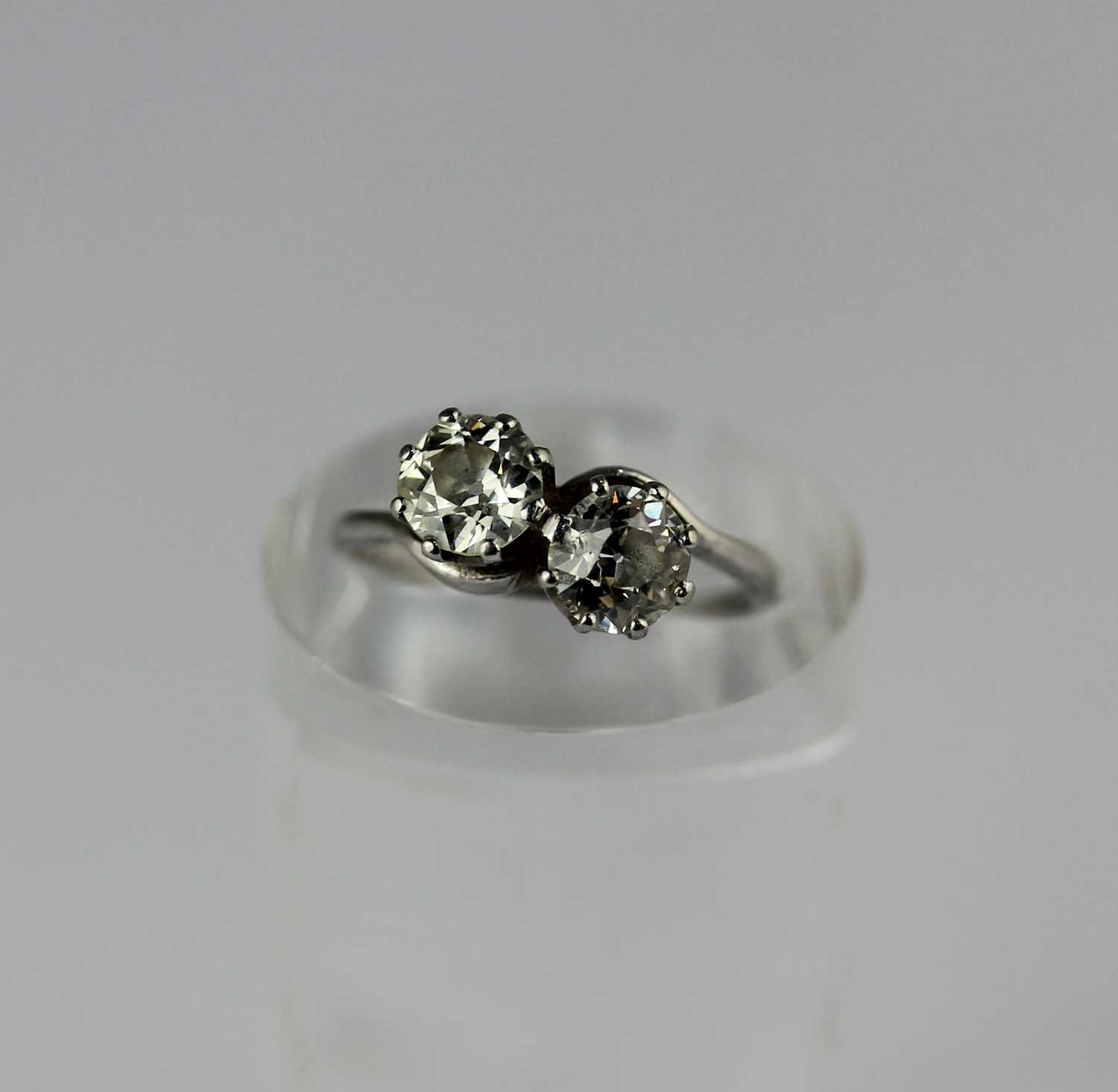 A diamond two stone ring claw set with cushion shaped diamonds in a crossover design, detailed '