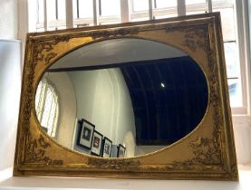 An ornate Georgian revival gilt framed wall mirror, 20th century, the oval mirror within rectangular