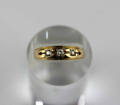 A Victorian 18ct gold ring mounted with two cushion shaped diamonds and with a central colourless