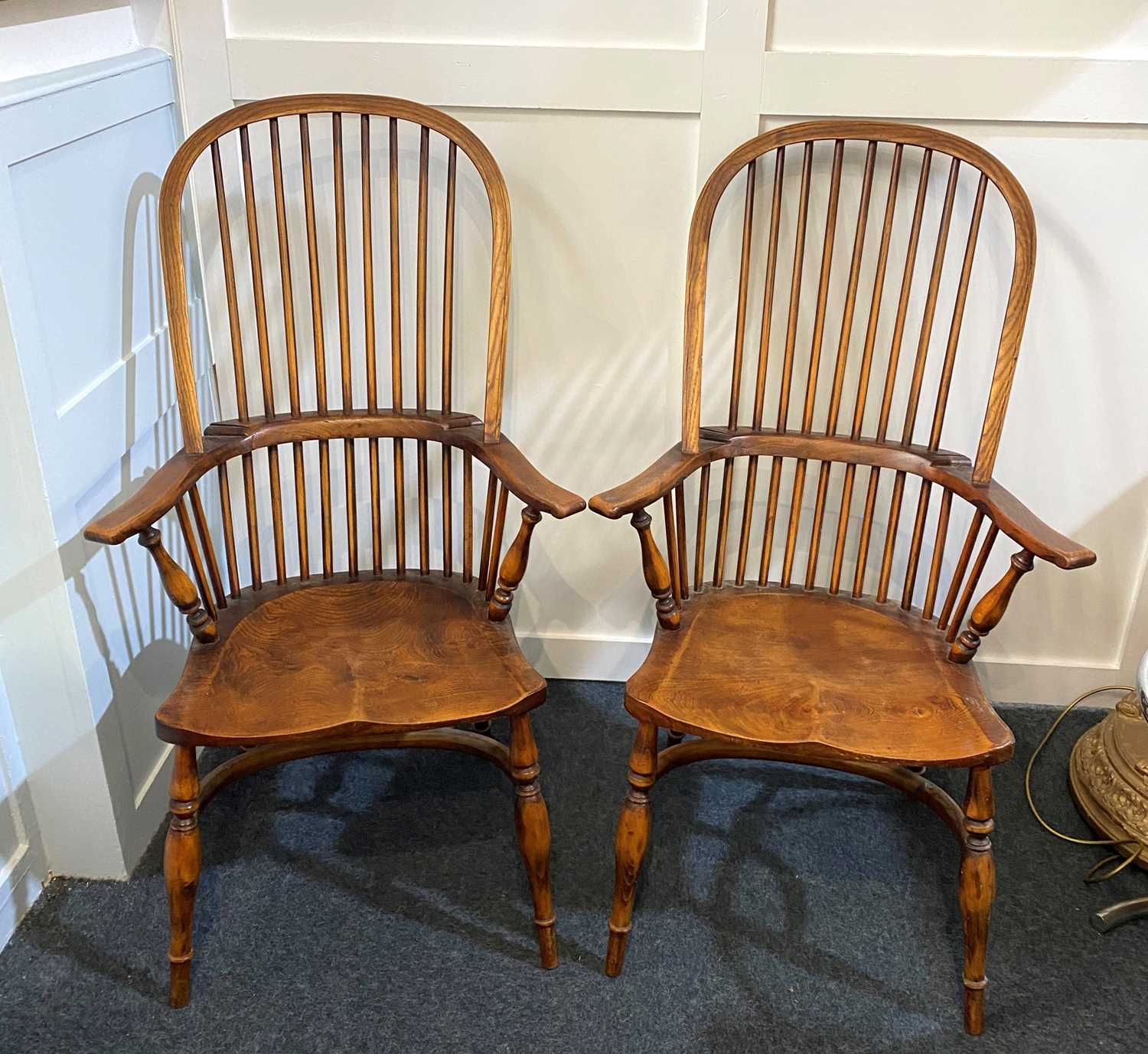 A pair of Georgian style elm and beech hoop and stick back Windsor chairs, raised on turned