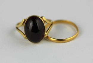 A gold ring mounted with an oval carbuncle garnet, unmarked, ring size K, gross weight 3.9g, and a