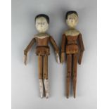 Two antique pegged wooden dolls, with hand painted features, jointed limbs, 30cm and 29cm long (2).