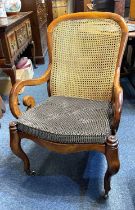 A 19th Century mahogany framed caned bergere armchair, with scrolled open arms, serpentine front,