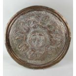 A 19th century Indian Mughal copper charger decorated in repousse and chasing portraying the