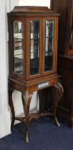 A French gilt metal mounted display cabinet platform top above two doors enclosing two glass shelves