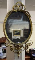 A giltwood and gesso girandole wall mirror, the oval mirror plate with pierced ribbon surmount and
