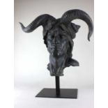 A contemporary bronzed sculpture modelled as a Demon mask, raised on a metal stand, overall combined