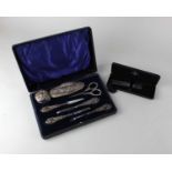 A cased George V silver manicure set comprising five various tools, silver topped glass pot and a